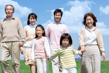 芝生を歩く三世代家族