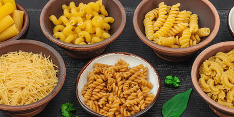 Pasta. Various kinds of uncooked pasta and noodles over wooden background. Traditional Italian