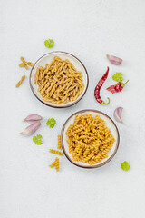 Pasta. Various kinds of uncooked pasta and noodles over light stone background. Traditional Italian