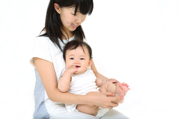 白背景で赤ちゃんを抱き、一緒に遊ぶお母さん。母性,幸福,愛情,育児イメージ