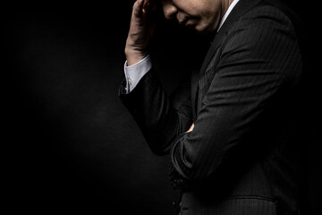 頭を抱えて悩む男性