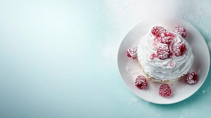 Fototapeta premium A white plate with a frosted cake and raspberries on a blue table