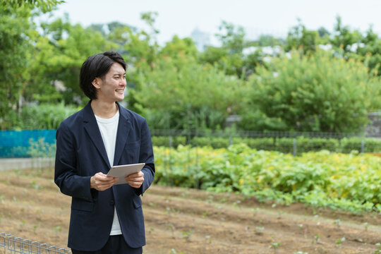 畑を管理する若い男性・ITとAIの活用