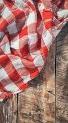 Fototapeta premium Red and white checkered fabric on rustic wooden background. Perfect for country-themed projects, picnics, and home decor inspiration.