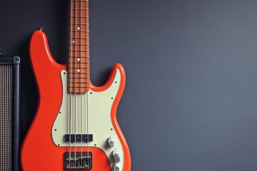 Red electric bass guitar with amplifier on grey background
