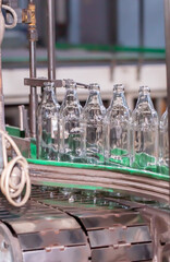 Glass factory, production of glass containers. Molten glass is blown into molds. Robotics in industry. Modern technologies, robotic machines produce products. Technological work at the plant.