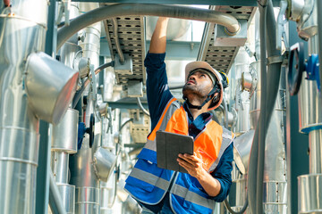 Professional Asian man engineer in safety uniform working on digital tablet at outdoor construction...