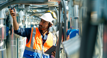 Professional Asian man engineer in safety uniform working on digital tablet at outdoor construction...