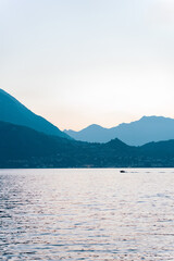 A boat sails on a mountain lake in Italy