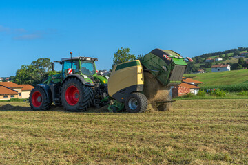 Obraz premium A farm tractor is pulling a grain harvester