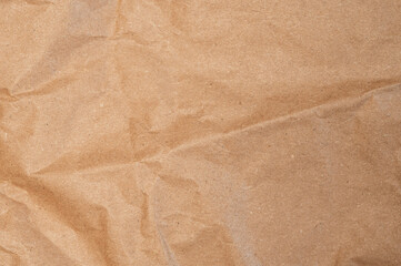 Brown craft baking paper sheet top view background, parchment for baking culinary, piece of wrinkled or crumpled paper texture