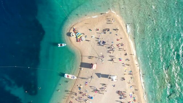 Bol, Zlatni Rat, Croatia, captured in a dynamic hyperlapse. The video showcases the vibrant summer life on the beach, with boats, sunbathers,and the energetic atmosphere of this famous spot.Brac(Brač)