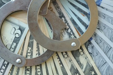 Handcuffs and a lot of dollars scattered on the table