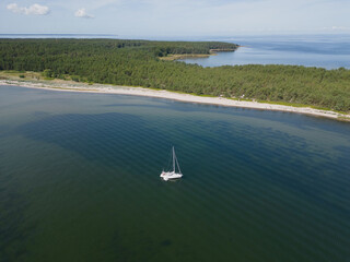 A sailing yacht is anchored off the coast of the Estonian island of Aegna on a summer day, photo...