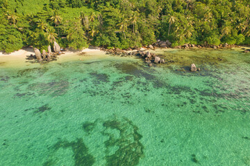 Drone aerial shot of Anse royale, fairy land of beautiful white sandy beach with granite stones and lush greenery, Mahe Seychelles