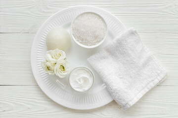 Layout of white cosmetics products and roses flowers, top view