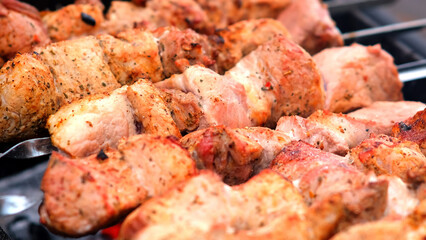 Close-up of sizzling kebabs on skewers grilling over an open flame. Perfect for showcasing outdoor cooking and barbecue flavors.