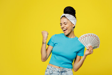 Young Latin woman she wears blue top t-shirt headband casual clothes hold in hand fan of cash money...