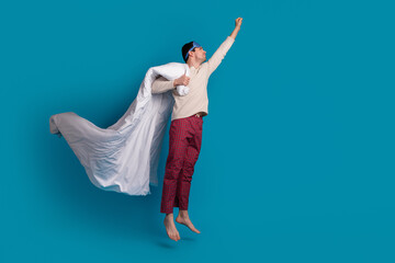 Full body photo of attractive young man flying superhero dressed pajama sleepover good night isolated on blue color background