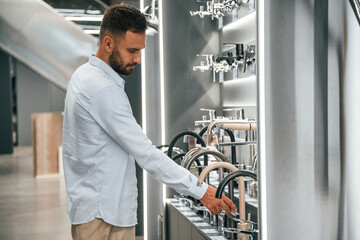 Fototapeta premium In a room with plumbing equipment. Man is in the hardware shop