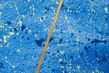 A vibrant abstract wallpaper featuring a blue acrylic surface accented with a striking golden line and colorful drops of paint