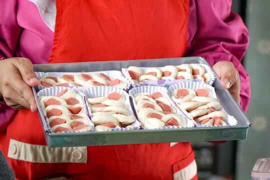Hand holding a tray of sausage bread