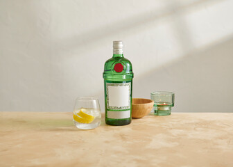 Green bottle alcohol with candle and lemon water.