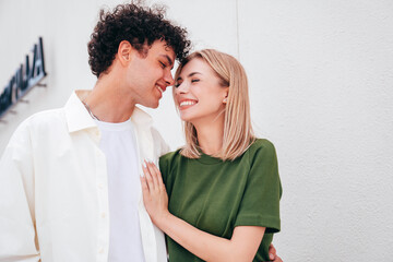 Smiling beautiful woman and her handsome boyfriend. Couple in casual summer clothes. Happy cheerful family. Female and man having fun. They posing in the street in sunny day. Having tender moments