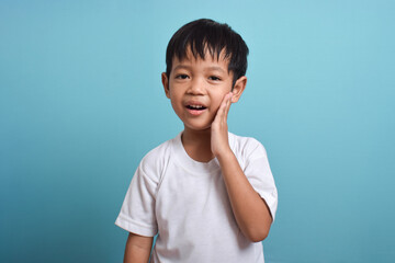 Little Asian boy suffering from toothache. emotional Asian boy who is suffering. A sad child with a...