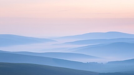 Obraz premium Rolling hills fading into the distance through layers of smoky haze with a soft pastel sky overhead