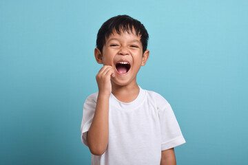 Little Asian boy suffering from toothache. toothache emotions large inflated cheek. A sad child...