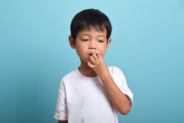 Little Asian boy suffering from toothache. emotional Asian boy who is suffering. A sad child with a...