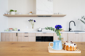 Wooden kitchen table with blue mug and sweet cake