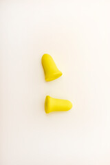 Yellow earplugs on a white background. Hearing protection products.