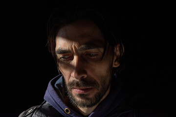 mirada baja de hombre con poca luz sobre su rostro