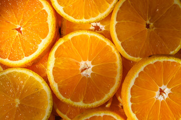 Colorful slices of fresh oranges as background with sun rays
