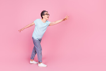 Full body portrait of nice aged lady run catch empty space isolated on pink color background