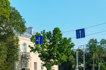 City street with old house in the morning. Bottom view of road signs with direction of movement by...