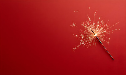 Close-up of a sparkler on a red background. New Year's and Merry Christmas concept. New Year banner with red background.