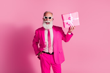 Photo of serious old cool man gentleman boyfriend hold present wear sunglass stylish pink suit isolated over pastel color background