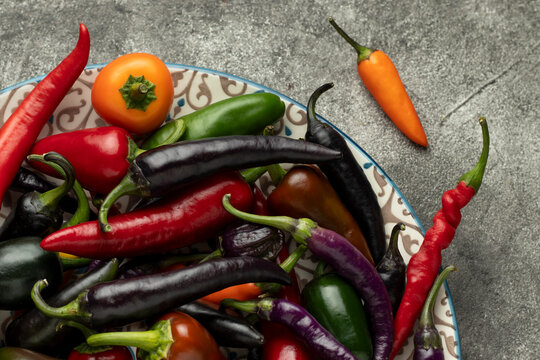 Mix of hot cayenne, jalapeno and buena mulata peppers on a plate.