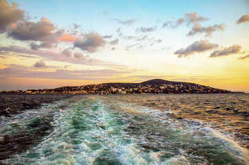 view of buyukada island under large colorful cloudy sky in the sunset, prince islands, adalar, istanbul