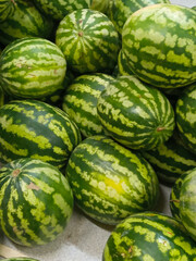 Watermelons in the supermarket. There are a lot of watermelons on the market. Fresh, ripe, juicy, whole watermelons. Harvesting. Background. A place for the text.