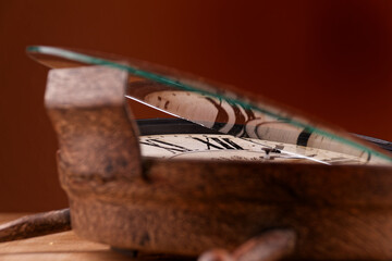 Broken old analog clock with glass and metal frame on wooden table, broken structure