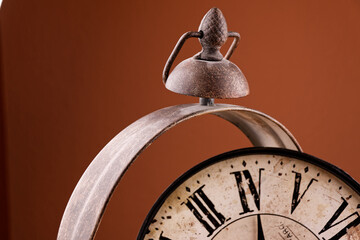 Broken old analog clock with glass and metal frame on wooden table, broken structure