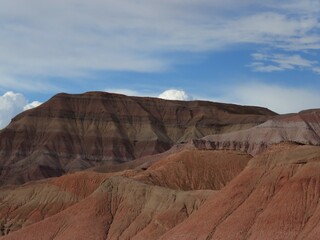Nature Landscape Photo of Painted Desert Brown Striped Hill under Blue Sky with Wispy White Clouds in Arizona