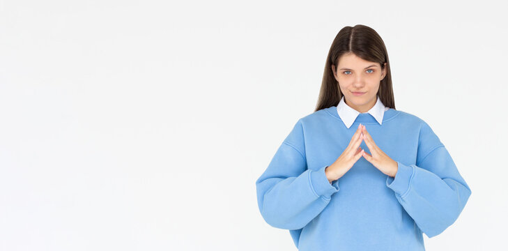 I have great evil plan. Confident and tricky woman in blue sweatshirt, holding fingers together and smirking at camera, having some bad intention in mind, planning to commit crime