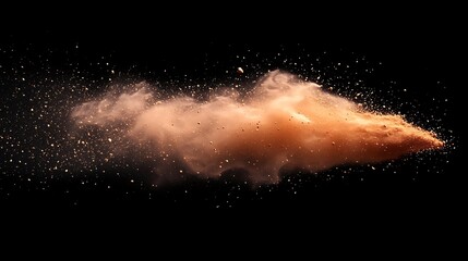 A burst of orange dust against a black background, creating a cloud of swirling particles.