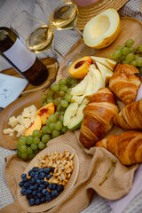 Aesthetic picnic. Natyarmort croissant, fruit, melon, grape, apple and wine. Summer picnic with fresh fruit and croissants in the garden.