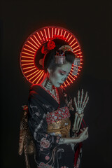 Fototapeta premium A woman in a black kimono is holding a skeleton